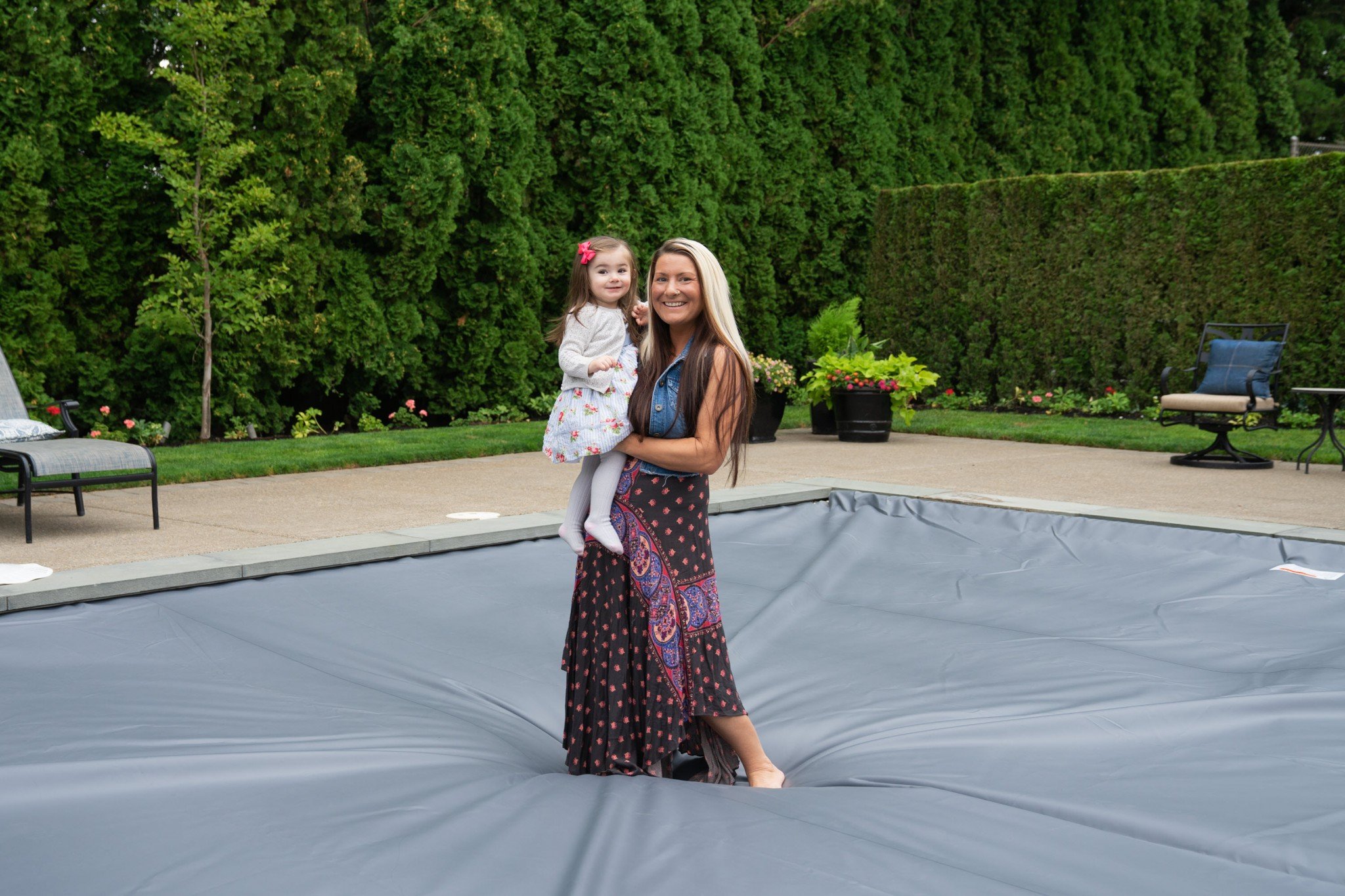 Mother and Daughter standing on an automatic swimming pool safety cover